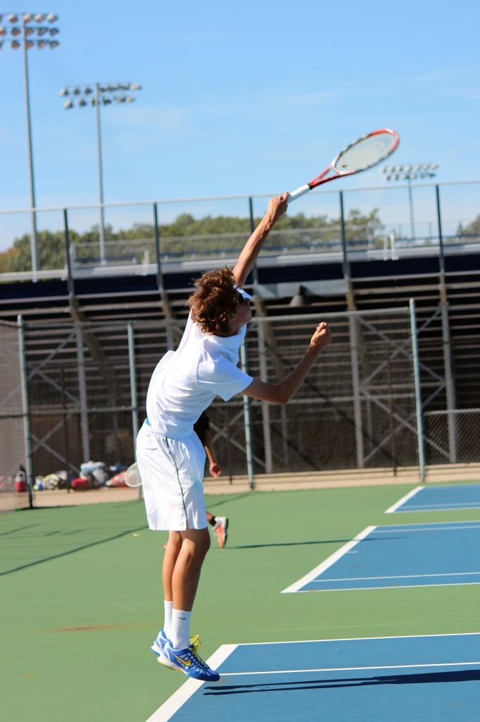 Doubles player _________ swings to serve 