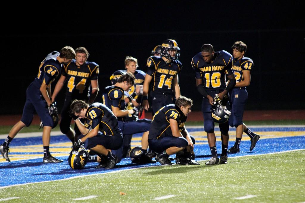 Completely dejected, Grand Haven players gather in the endzone. (Hayes)