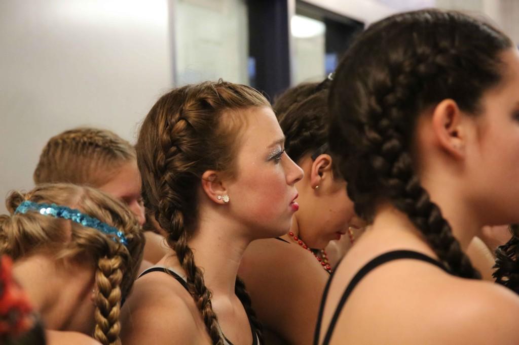 Senior Roxy Glasser listens to the officers as they give a final pep talk before the last show of the weekend.