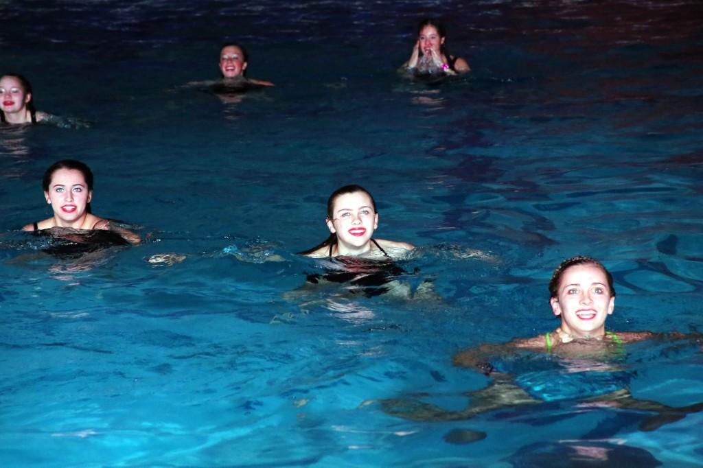 Sophomore Anna Dexter along side officer Claire Borchers (right) and senior Carly Grove (left) smile while forming an X formation during the "Mermaid".